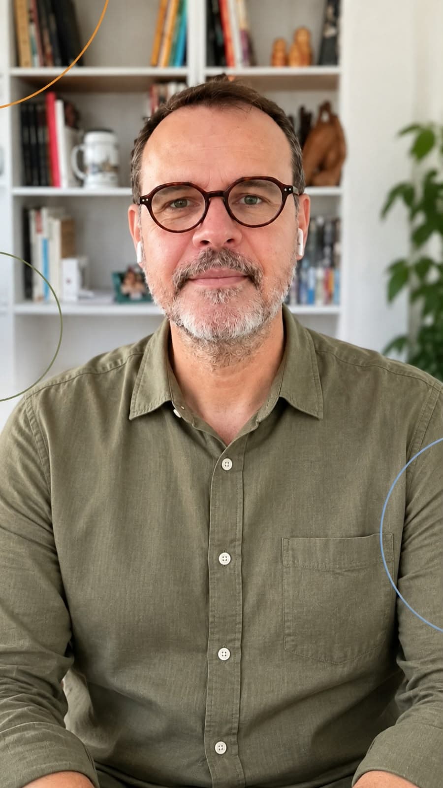 Kleber Moreira, de camisa verde e óculos, diante de sua biblioteca